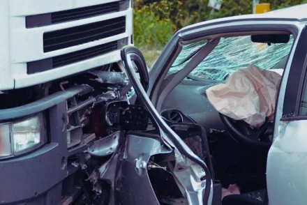 Collision of a truck and a grey car.