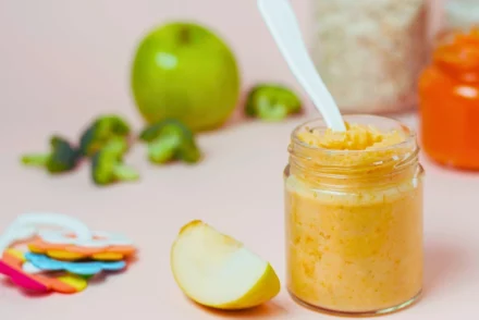 Baby puree on a jar with spoon on it.