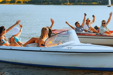Happy group of boys and girls boating on a summer day.