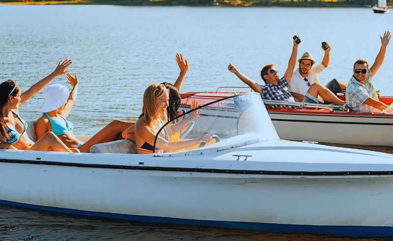 Happy group of boys and girls boating on a summer day.